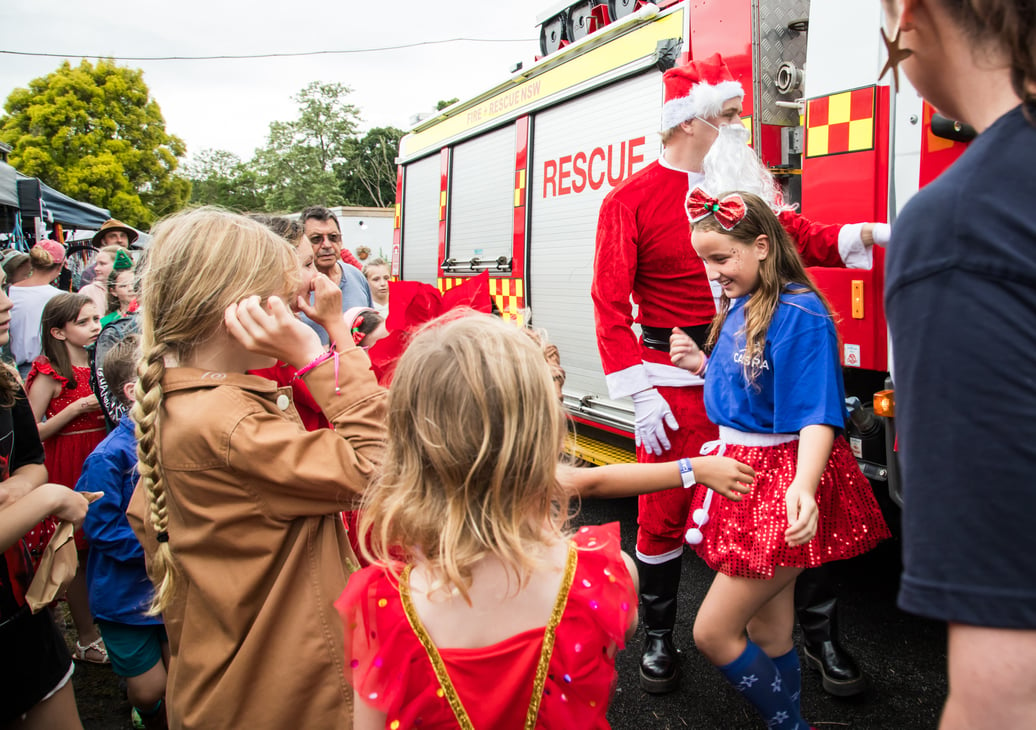 Santa and his helper arrive on the RFS truck at the CASPA Christmas Carnival to hand out lollies and festive cheer.