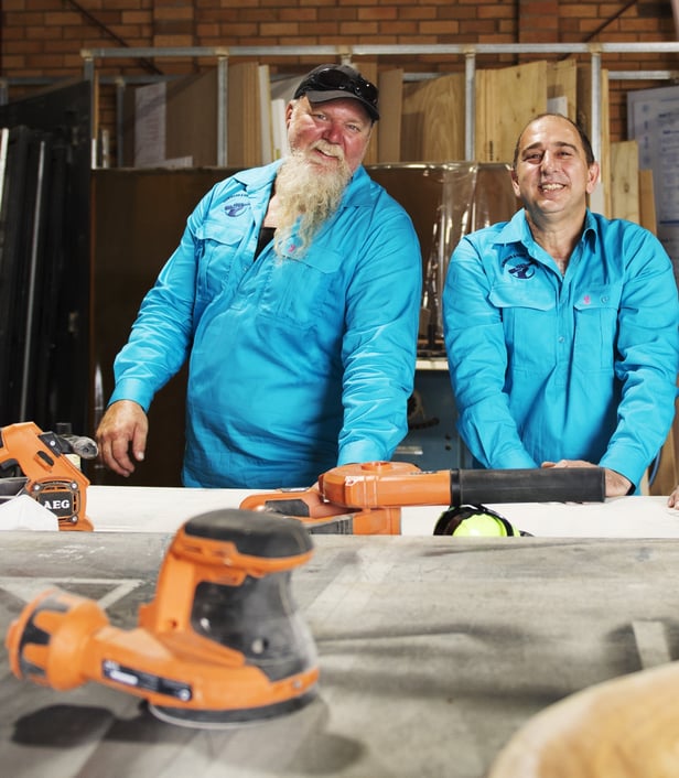 Two happy Hammers 4 Hope employees in their workshop
