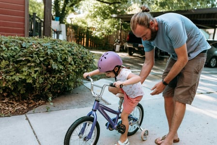 Bike riding helmet young girl dad training wheels learning teaching